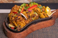 a plate of chicken tikka masala on a wooden table