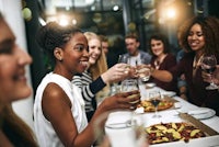 a group of people toasting at a dinner party